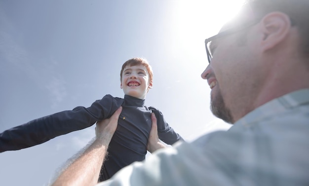 Foto estilizada um pai feliz segura seu filho nas mãos o conceito de paternidade