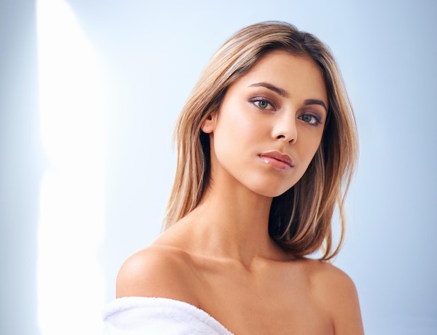 Foto de estudio de belleza radiante de una hermosa mujer joven contra un fondo azul.