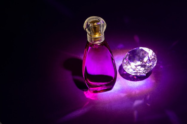 Foto de estudio de botellas de perfume sobre fondo de color con reflexión. Perfumes, cosméticos, una colección de fragancias.