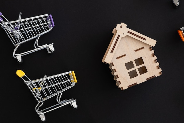 Foto de estudio de casa hecha de bloques de juguete en un pequeño carrito de compras