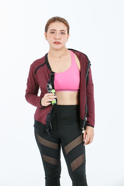 Foto de estudio de cuerpo completo de recorte aislado de retrato de modelo de atleta femenina fuerte en forma asiática en sujetador deportivo superior recortado y chaqueta exterior con legging y zapatos para correr de pie posando sobre fondo blanco