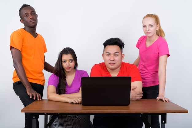 Foto de estudio de diverso grupo de amigos multiétnicos sentados