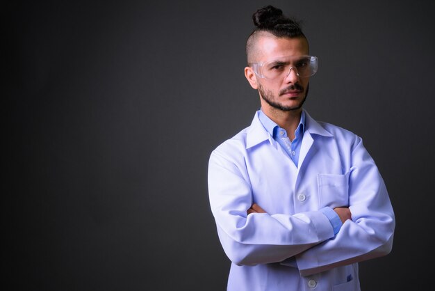 Foto de estudio de guapo médico turco con gafas protectoras contra el fondo gris