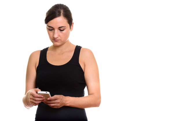 Foto de estudio de hermosa mujer mediante teléfono móvil