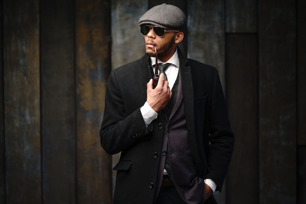 Foto de estudio de hombre elegante vestido con un abrigo