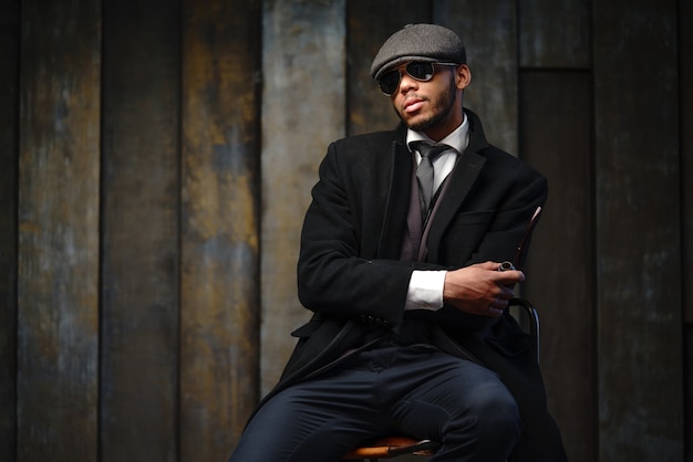 Foto de estudio de hombre elegante vestido con un abrigo