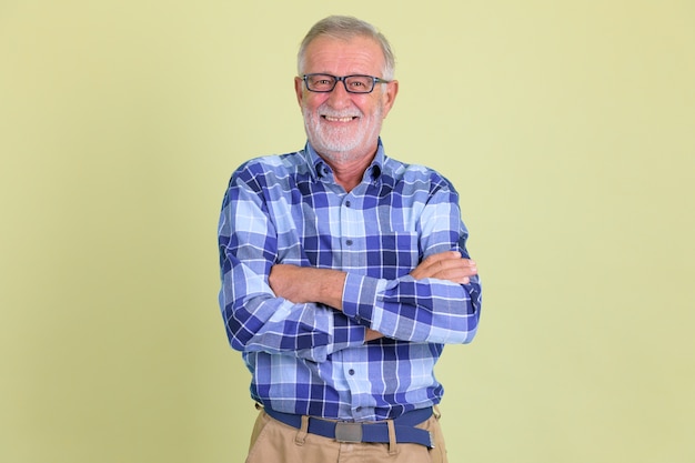 Foto de estudio de hombre guapo hipster barbudo senior contra el fondo de color