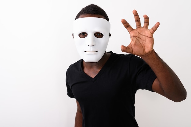 Foto de estudio de joven africano negro con máscara y mostrando