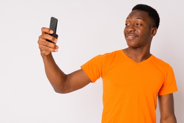 Foto de estudio de joven apuesto hombre africano con cabello afro contra el fondo blanco.