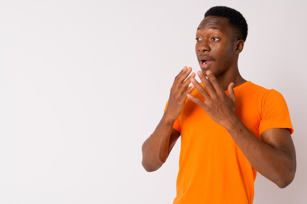 Foto de estudio de joven apuesto hombre africano con cabello afro contra el fondo blanco.