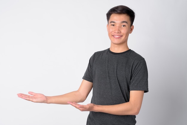 Foto de estudio de joven apuesto hombre asiático contra el fondo blanco.