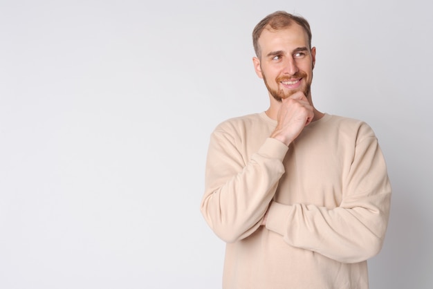 Foto de estudio de joven barbudo contra un blanco