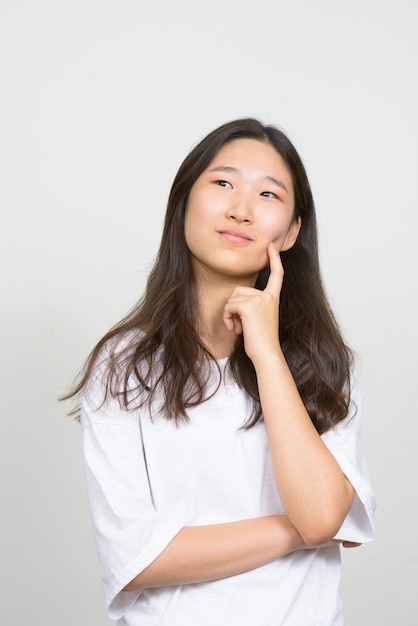 Foto de estudio de la joven y bella mujer coreana contra el fondo blanco.