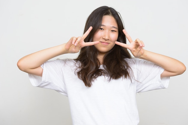 Foto de estudio de la joven y bella mujer coreana contra el fondo blanco.