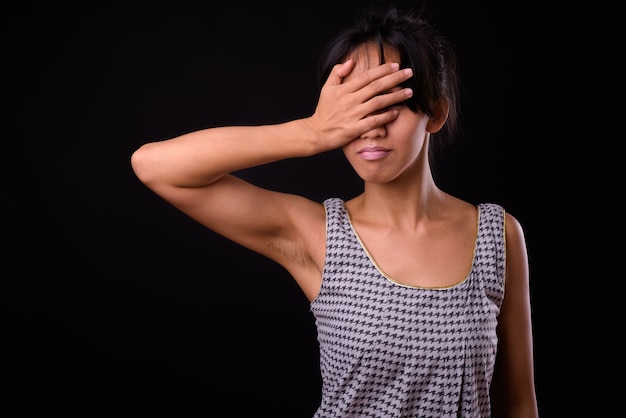 Foto de estudio de la joven y bella mujer filipina contra el fondo negro