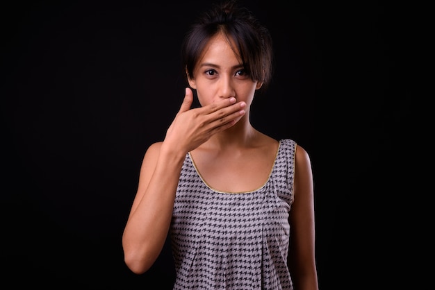 Foto de estudio de la joven y bella mujer filipina contra el fondo negro