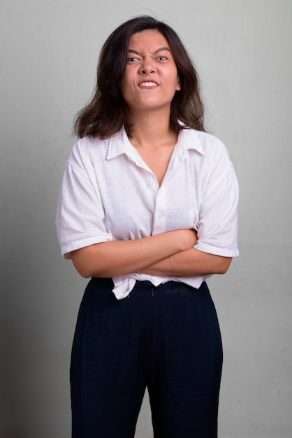 Foto de estudio de joven bella mujer con pelo corto contra un blanco