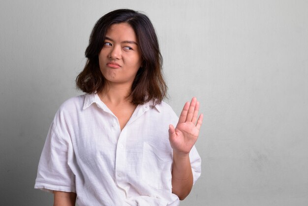 Foto de estudio de joven bella mujer con pelo corto contra un blanco