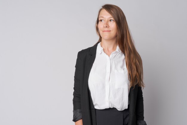 Foto de estudio de la joven empresaria hermosa contra un blanco