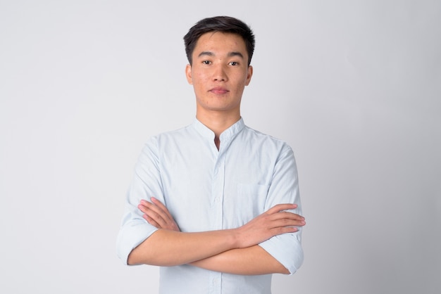 Foto de estudio de joven empresario asiático guapo contra el fondo blanco.