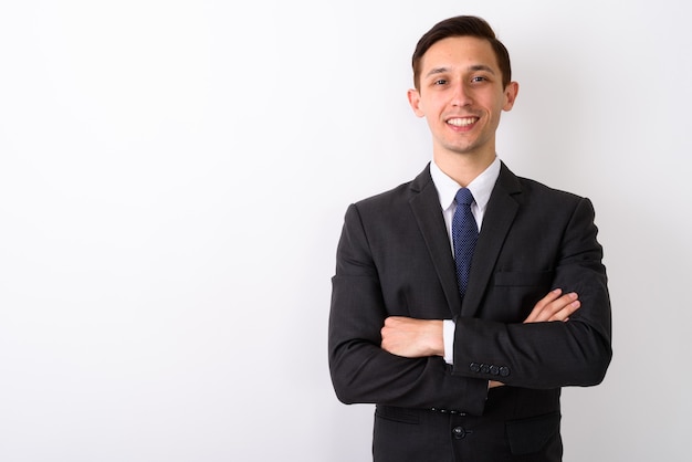 Foto de estudio de joven empresario feliz sonriendo con los brazos cruzados