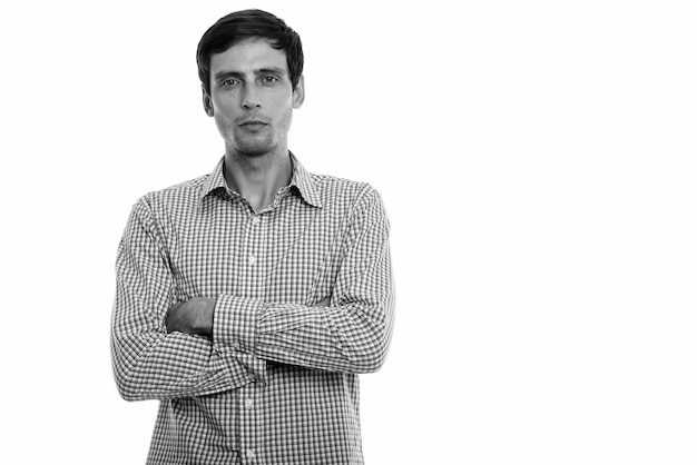 Foto de estudio de joven empresario guapo con barba incipiente aislado sobre fondo blanco en blanco y negro