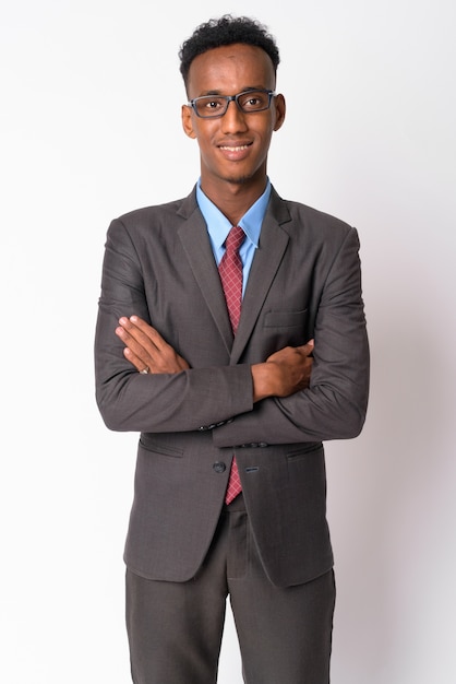 Foto de estudio de joven empresario guapo con pelo afro vistiendo traje contra un blanco