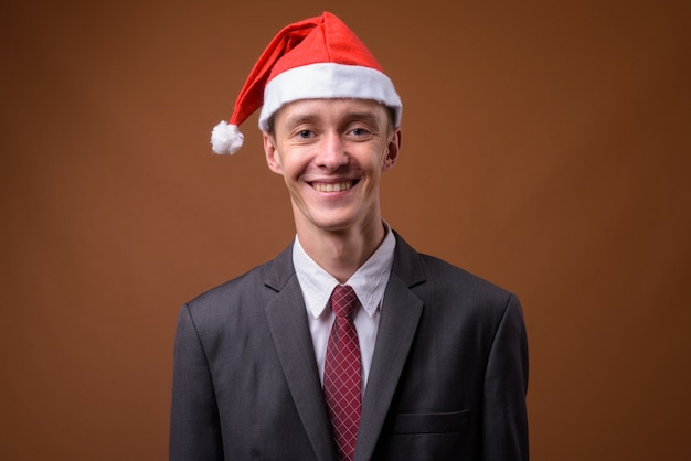 Foto de estudio de joven empresario en marrón