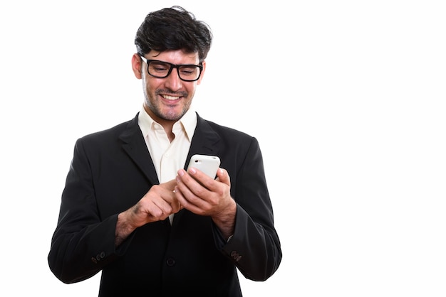 Foto de estudio de joven empresario persa feliz sonriendo mientras usi