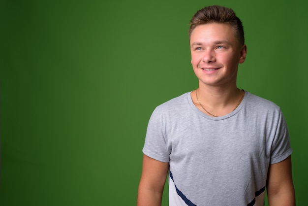 Foto de estudio de joven guapo contra fondo verde