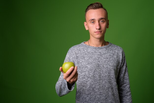 Foto de estudio de joven guapo contra fondo verde