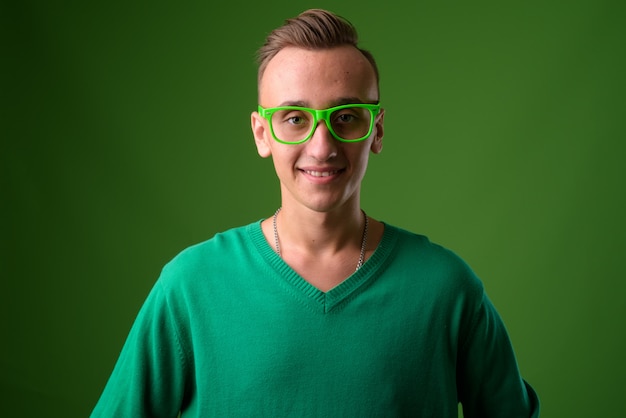 Foto de estudio de joven guapo contra fondo verde