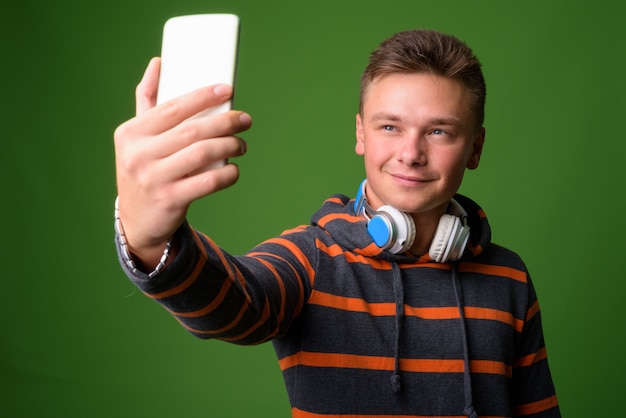 Foto de estudio de joven guapo contra fondo verde