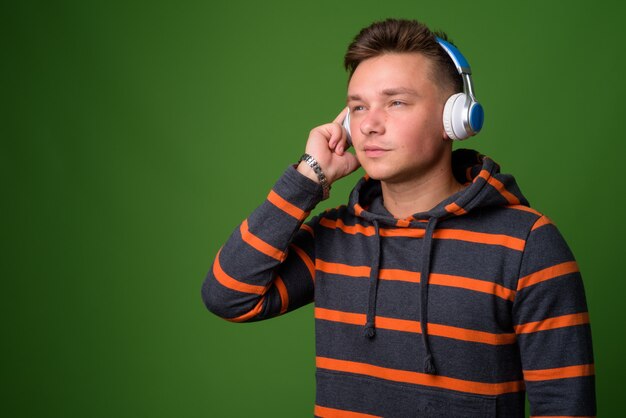 Foto de estudio de joven guapo contra fondo verde