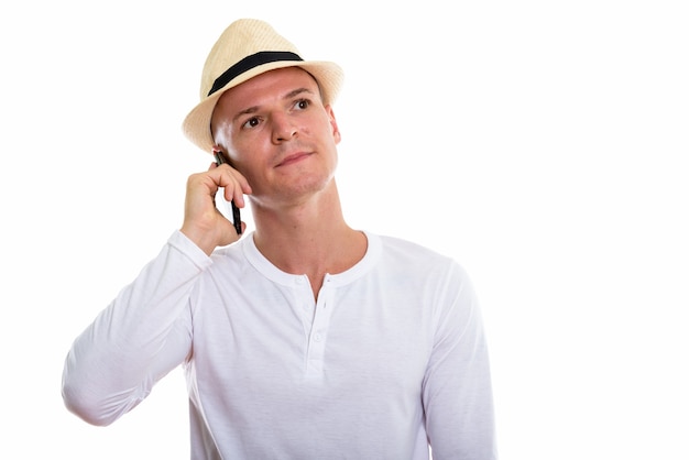 Foto de estudio de joven guapo hablando por teléfono móvil mientras