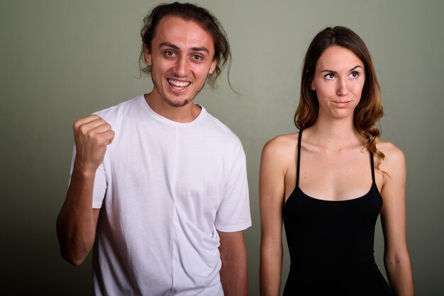 Foto de estudio de joven guapo y joven mujer hermosa juntos contra el fondo de color