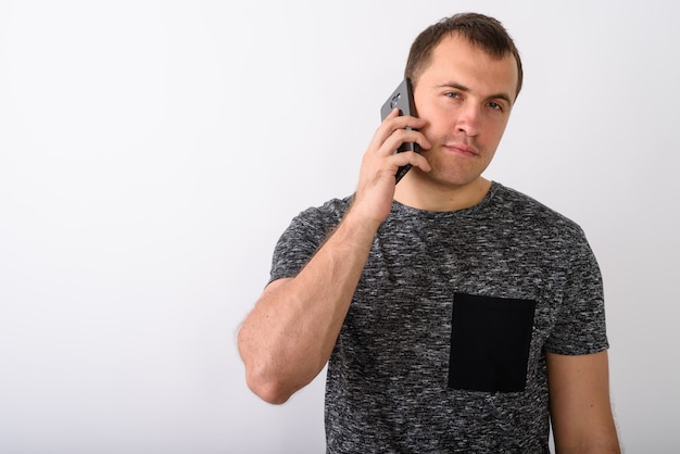 Foto de estudio de joven musculoso hablando por teléfono móvil otra vez