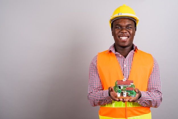 Foto de estudio de joven trabajador de la construcción africana contra el fondo blanco.