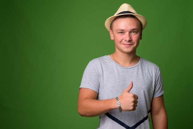 Foto de estudio de joven turista guapo contra backgrou verde