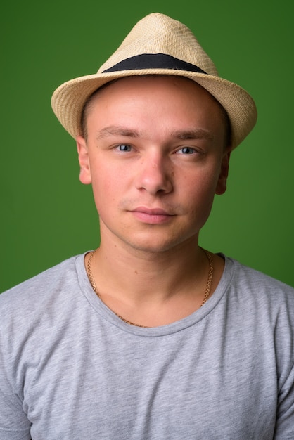 Foto de estudio de joven turista guapo contra backgrou verde