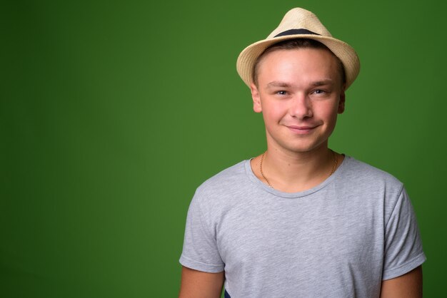 Foto de estudio de joven turista guapo contra backgrou verde