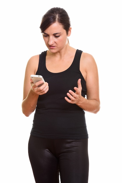 Foto de estudio de mujer enojada sosteniendo teléfono móvil