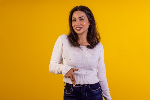 Foto de estudio de mujer joven con camisa blanca sobre fondo amarillo con diversas expresiones faciales