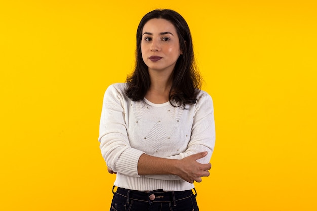 Foto de estudio de mujer joven con camisa blanca sobre fondo amarillo con diversas expresiones faciales