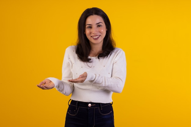 Foto de estudio de mujer joven con camisa blanca sobre fondo amarillo con diversas expresiones faciales