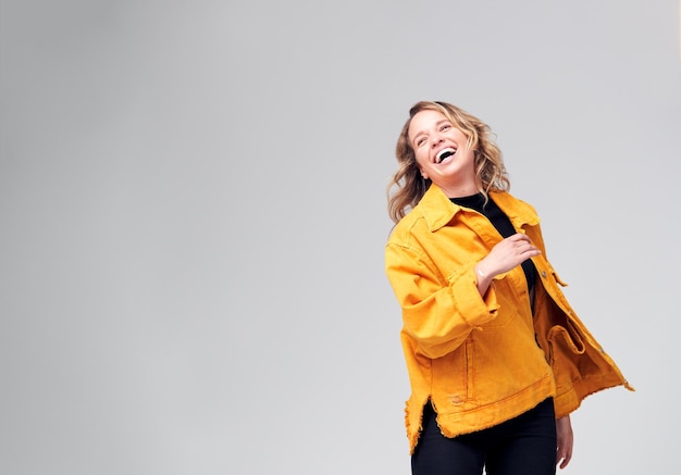 Foto de estudio de mujer joven contra el fondo blanco divirtiéndose bailando