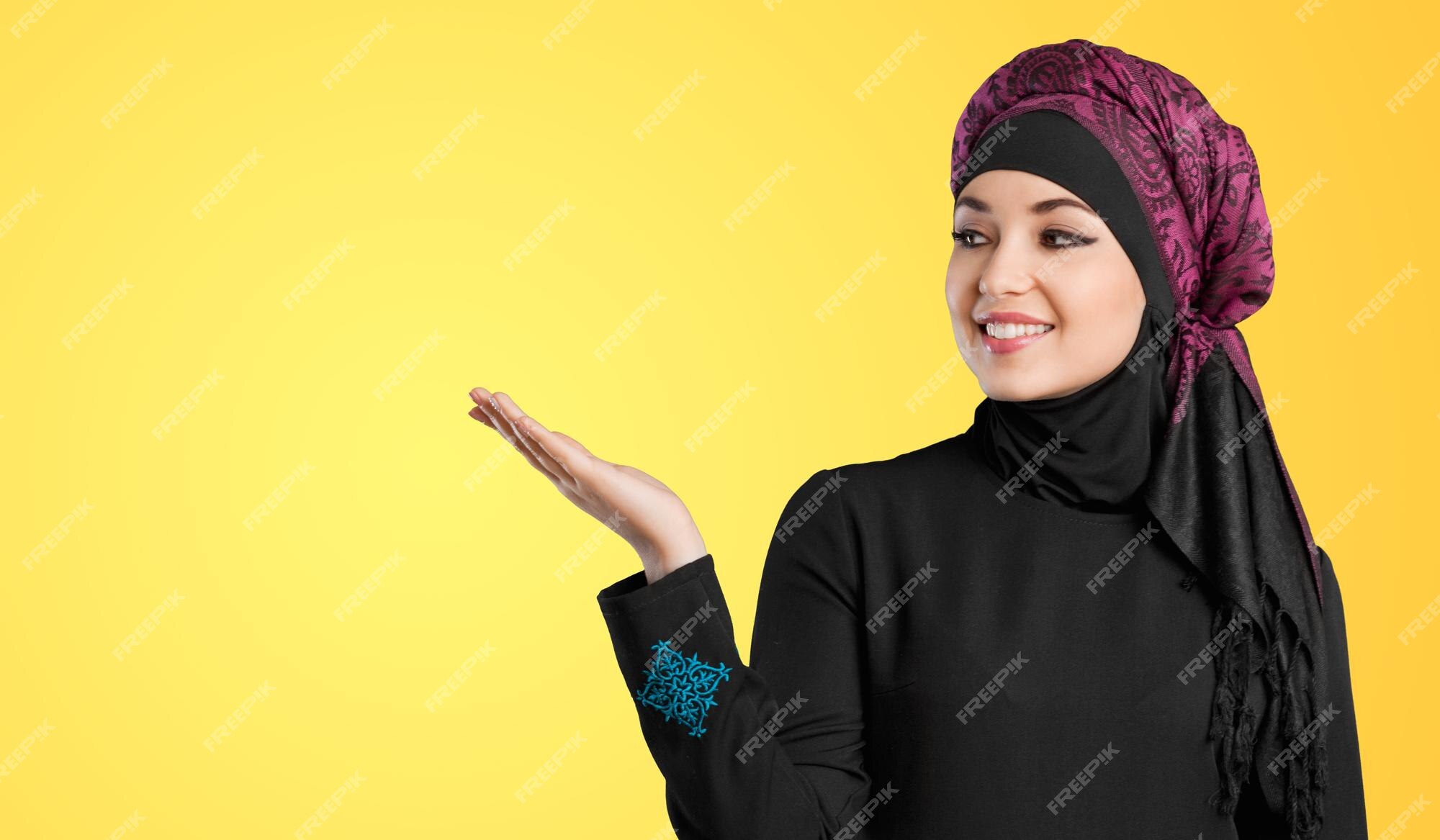 de estudio de una mujer joven con ropa árabe tradicional. ella está sosteniendo su mano a un lado | Foto Premium