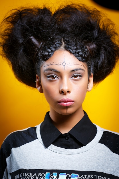 Foto de estudio de niña latina en pared amarilla