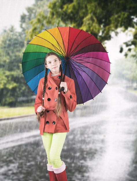 Foto de estudio de una niña con paraguas de colores