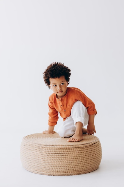 Foto de estudio de un niño de piel oscura vestido con ropa cómoda de lino